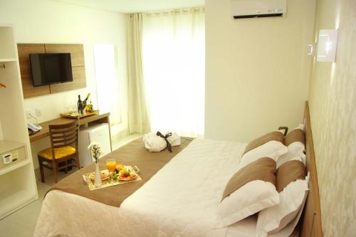 a bedroom with a bed with a tray of fruit on it at Hotel Flor Da Chapada in Itaberaba