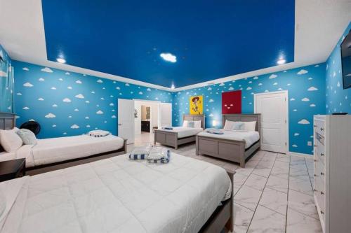 a bedroom with two beds and a blue wall at Magic Marvel Getaway in Kissimmee