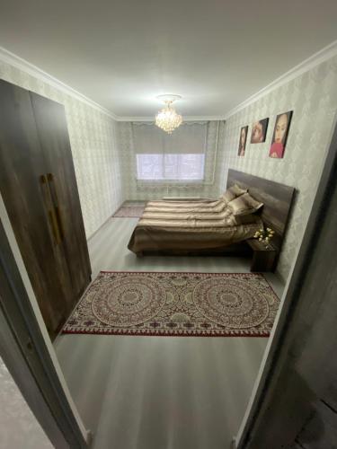 a small bedroom with a bed and a chandelier at Микрорайон Самал дом 38 in Taraz
