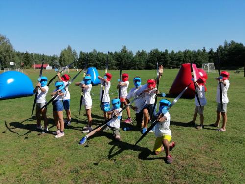 a group of young children playing a game with arrows at Ośrodek Wypoczynkowy Kalwa in Pasym