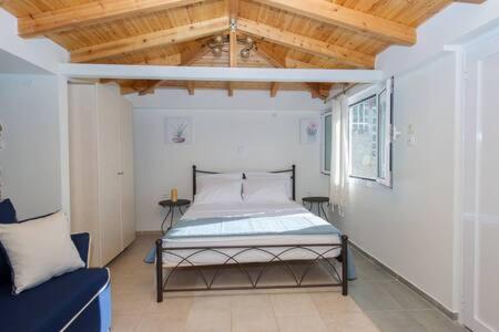 a bedroom with a bed in a room with a wooden ceiling at Villa Needa's - New Hope Poolside Studio in Mírton