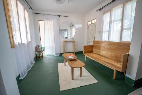 a room with a bench and a table and a mirror at Mkoani Homestay in Moshi