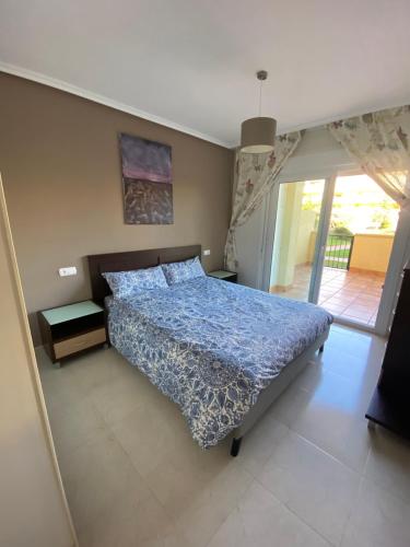 ロケタス・デ・マルにあるVictor Villa Romanaのベッドルーム1室(青い掛け布団付きのベッド1台付)