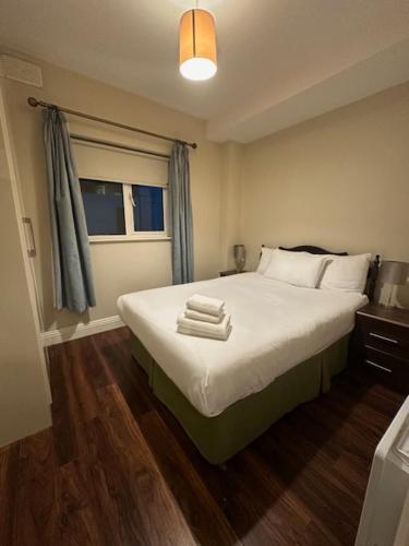 a bedroom with a bed with towels on it at St Bridget's Apartments in Galway