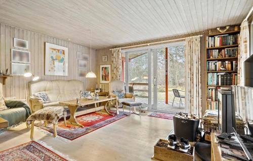 ein Wohnzimmer mit einem Sofa und einem Tisch in der Unterkunft 3 Bedroom Lovely Home In Nex in Vester Sømarken