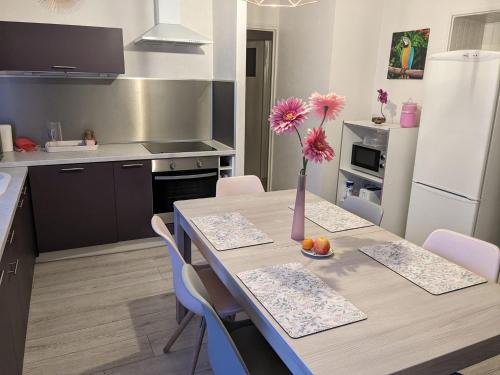 une cuisine avec une table avec un vase de fleurs dessus dans l'établissement Au Près du Zoo, à Saint-Aignan