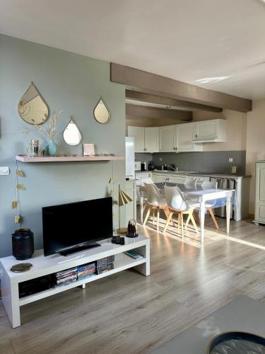 un salon avec une télévision et une table avec des chaises dans l'établissement Le Champlain Duplex Port de plaisance, à Dieppe