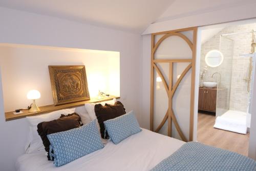 a bedroom with a white bed with blue pillows at Bed and Breakfast Shandita in Mérignac