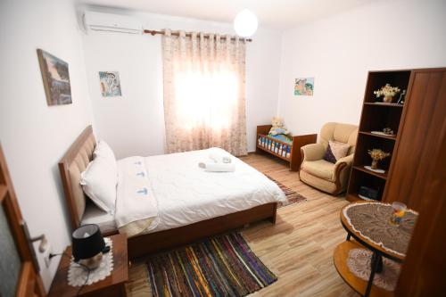 a bedroom with a bed and a chair in it at Guest House Luli in Berat