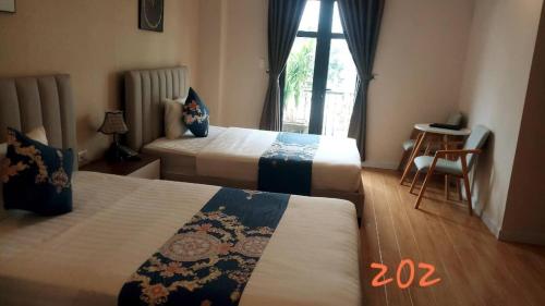 a hotel room with two beds and a window at Khách Sạn The One Hotel 1 in Cà Mau