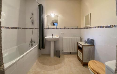 La salle de bains est pourvue d'un lavabo et d'une baignoire. dans l'établissement Lovely Home In Chich With House Sea View, à Chiché