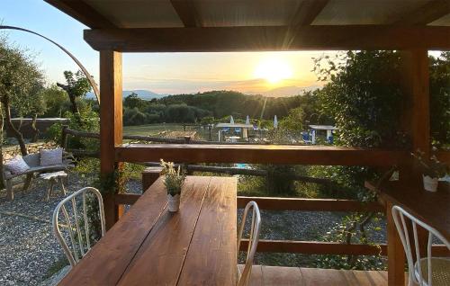 a wooden table and chairs on a porch with the sunset at Alloro 3 in Montecarlo