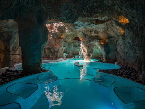 a pool of water in a cave with a waterfall at Hotel Mirador Papagayo by LIVVO in Playa Blanca