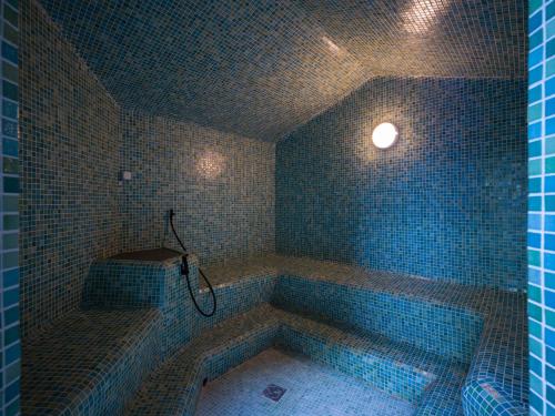 a blue tiled bathroom with a tub with a shower at Hotel Mirador Papagayo by LIVVO in Playa Blanca
