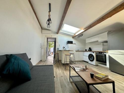a living room with a couch and a table and a kitchen at Ô Sorgue in LʼIsle-sur-la-Sorgue