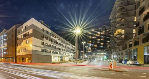 a city street at night with buildings and lights at PLAZA INN Wien Gasometer in Vienna