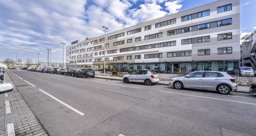 a row of cars parked in front of a building at PLAZA INN Wien Gasometer in Vienna