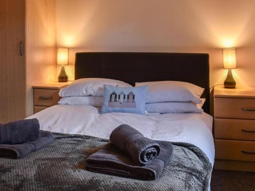 a bedroom with a large bed with towels on it at Picturesque Cabin in Cornwall in Camborne