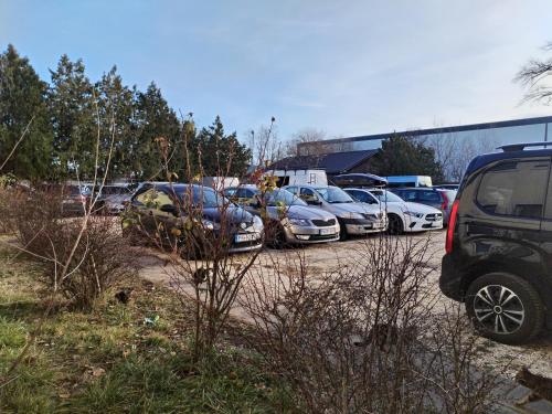 een stel auto's geparkeerd op een parkeerplaats bij Hostel Ferihegy in Vecsés