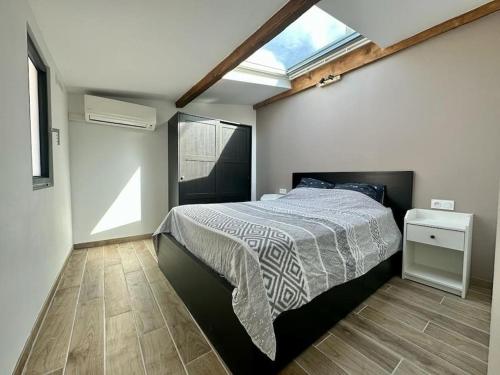een slaapkamer met een bed in een kamer met een raam bij Gîte indépendant en centre-ville in LʼIsle-sur-la-Sorgue