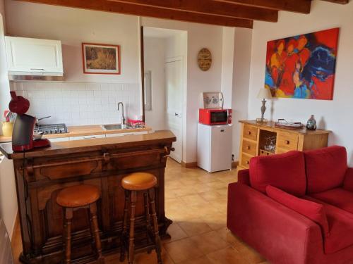 - une cuisine avec un comptoir et un canapé rouge dans la chambre dans l'établissement Domaine Le Beau Lavault, à Thil-sur-Arroux