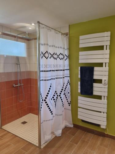 une douche avec une porte vitrée dans une salle de bain dans l'établissement Domaine Le Beau Lavault, à Thil-sur-Arroux