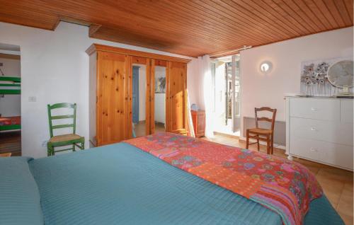 1 dormitorio con 1 cama azul y 2 sillas en 3 Bedroom Stunning Home In Marignana, en Marignana