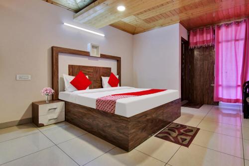 - une chambre avec un grand lit et des oreillers rouges dans l'établissement Flagship Kasauli View, à Dagshai