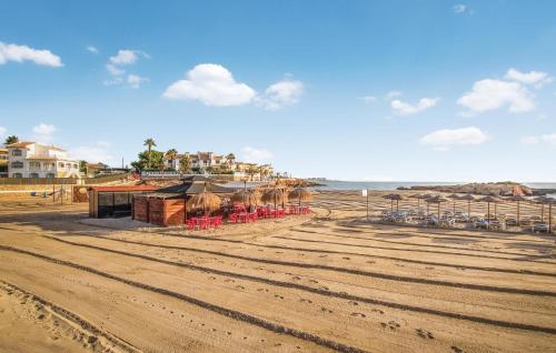 Una playa con sillas y sombrillas y el océano. en Awesome Apartment In Torrevieja, en Torrevieja