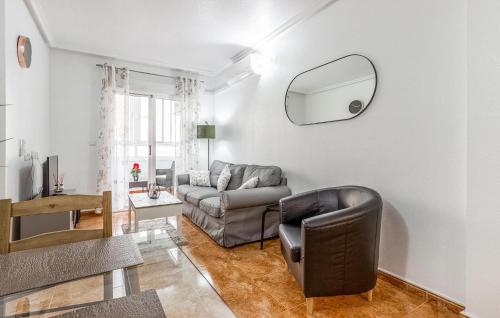 Una sala de estar con un sofá y un espejo. en Awesome Apartment In Torrevieja, en Torrevieja