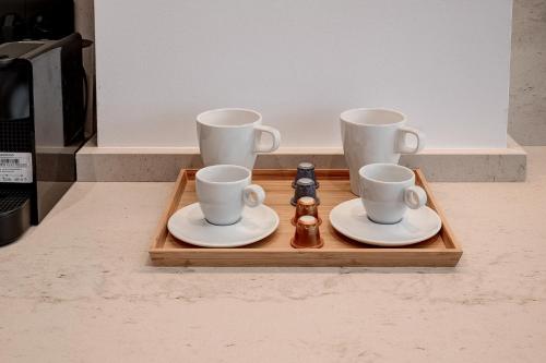 a tray with three cups and two saucers on it at CHANTTAL Luxury - BOUTIQUE in Bucharest