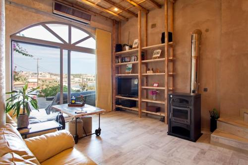 a living room with a fireplace and a couch and a stove at Lenico Beachfront Suites in Agia Pelagia