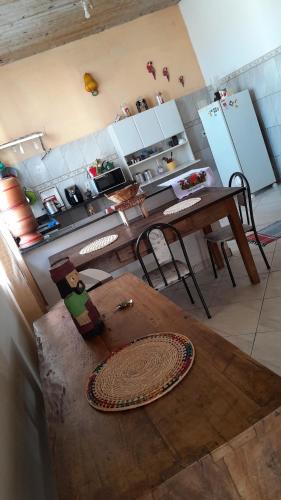 uma cozinha com uma mesa de madeira com cadeiras e uma mesa de sidx em Meu cantinho em Tiradentes