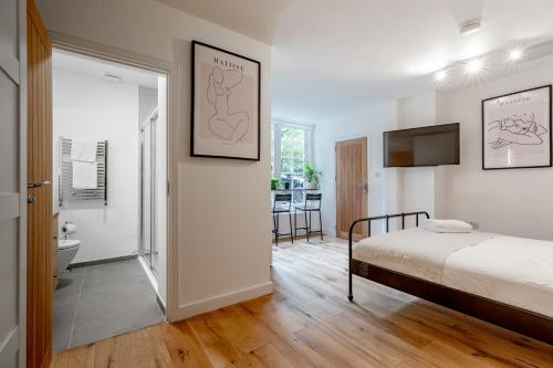 a bedroom with a bed and a flat screen tv at Charming Large Studio in Hampstead in London