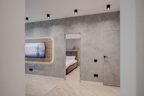 a bedroom with a bed and a tv on a wall at CHANTTAL Luxury - BOUTIQUE in Bucharest