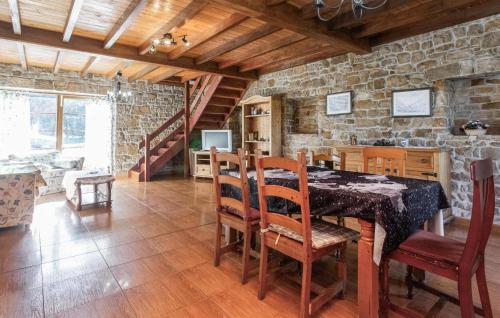 comedor con mesa, sillas y pared de piedra en 5 Bedroom Nice Home In Arguero, en Argüero
