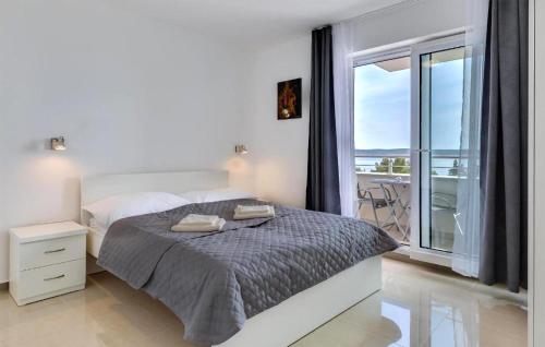 ein weißes Schlafzimmer mit einem Bett und einem großen Fenster in der Unterkunft Lovely Apartment In Tribanj With Kitchen in Šibuljina