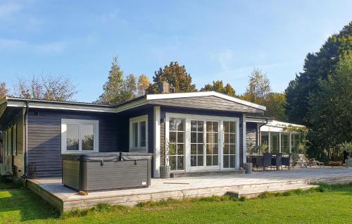 a blue house with a large deck in front of it at Gorgeous Home In Hjärnarp With Wifi in Hjärnarp