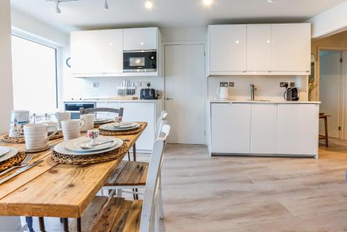 a kitchen and dining room with a wooden table and chairs at Sea Spray - Bracklesham Bay in Chichester