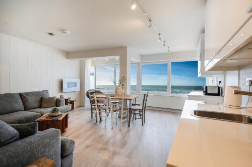 een woonkamer met een bank en een tafel met stoelen bij Sea Spray - Bracklesham Bay in Chichester