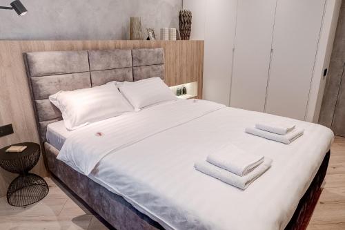 a bedroom with a large bed with towels on it at CHANTTAL Luxury - BOUTIQUE in Bucharest