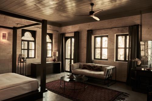 a bedroom with a bed and a couch and windows at Carus Cappadocia in Goreme