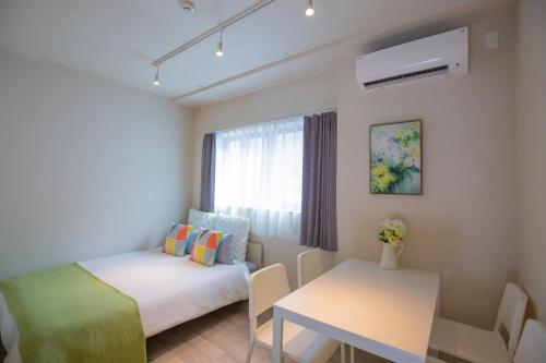 a small room with a bed and a table at The most comfortable and best choice for accommodation in Yoyogi SoSI in Tokyo