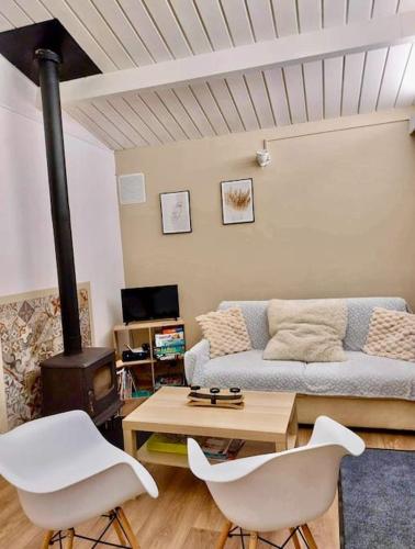 een woonkamer met een bank, stoelen en een fornuis bij Village de vacances d'Oignies in Petit Mesnil