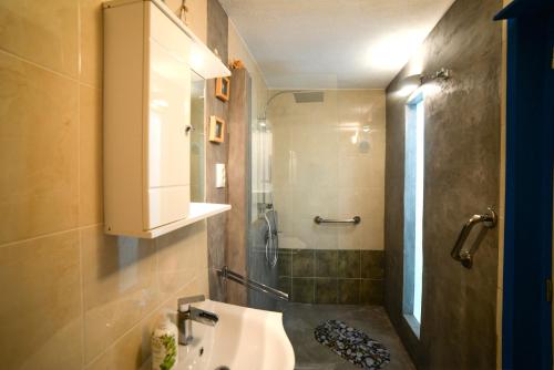 a bathroom with a sink and a shower at RURAL GUEST HOUSE B&B in Chavouna