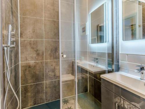 ein Bad mit einer Dusche und einem Waschbecken in der Unterkunft Luxury studio above the stunning Tenby Harbour in Tenby