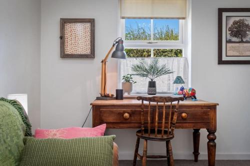 a desk in a room with a window and a chair at Luxury three bedroom coastal cottage in Cardigan