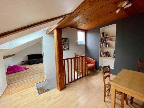 ein Wohnzimmer mit einem Esstisch und einer Treppe in der Unterkunft Au 81 - maison de ville à louer in Moirans