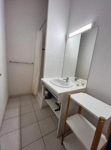 une salle de bain avec un lavabo et un miroir dans l'établissement Diste pavillon, à Vendres