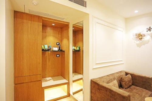 a living room with a couch and a mirror at JRD Luxury-Business Hotel in New Delhi